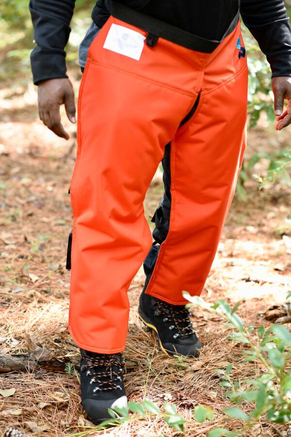SwedePro Essential-Apron-Chap orange front view being worn in forest with chainsaw protective boots